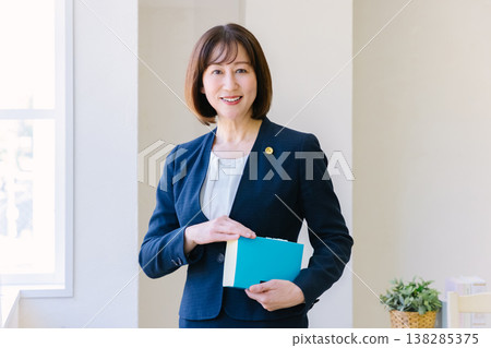A female lawyer stands by the window at a law firm. A female lawyer stands by the window at a law firm. 138285375