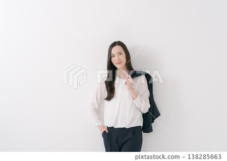 一位身穿西裝的女士,肩上披著一件外套。 一位身穿西裝的女士,肩上披著一件外套。 138285663