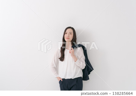一位身穿西裝的女士,肩上披著一件外套。 一位身穿西裝的女士,肩上披著一件外套。 138285664