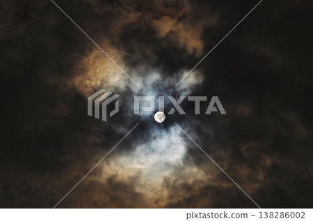 A hazy moon shines in the winter night sky 10 138286002