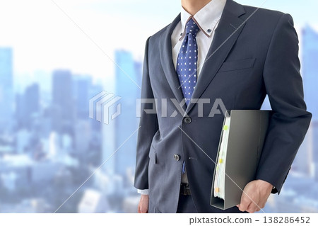A businessman carrying a file of documents 138286452