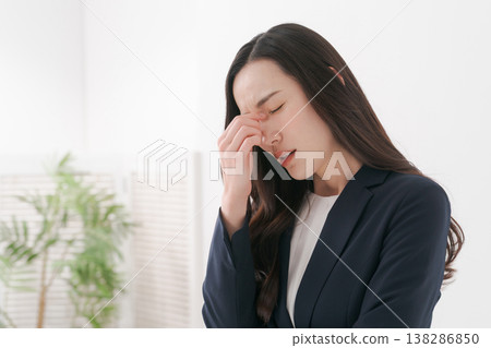 A woman in a suit with tired eyes 138286850