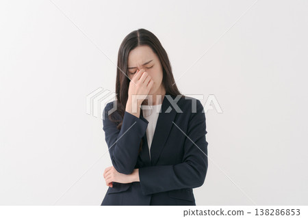 A woman in a suit with tired eyes 138286853