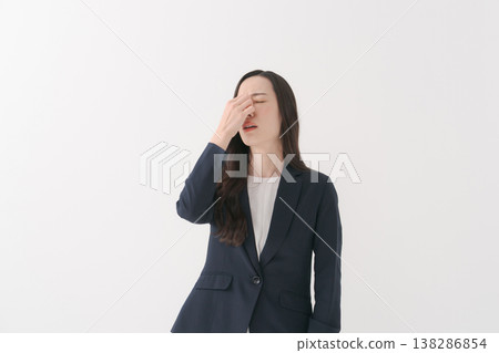 A woman in a suit with tired eyes 138286854