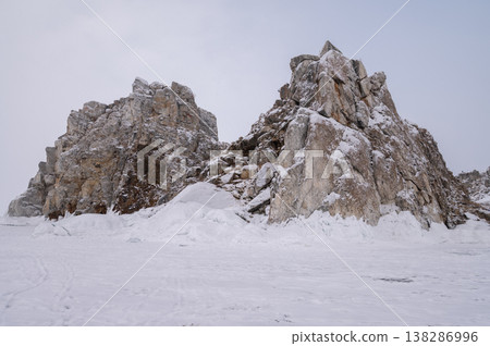 The Shaman rock at Burkhan cape covering by snow during winter season in Siberia, Russia. This rock is a subject of many popular legends and myths about Baikal Lake and Angara river. The Shaman rock at Burkhan cape covering by snow during winter season in Siberia, Russia. This rock is a subject of many popular legends and myths about Baikal Lake and Angara river. 138286996