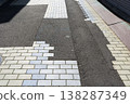 The brick sidewalk has been temporarily repaired with asphalt due to construction work - patched up. 138287349