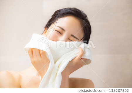 A woman wiping his face with a towel A woman wiping his face with a towel 138287892