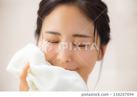 A woman wiping his face with a towel A woman wiping his face with a towel 138287894