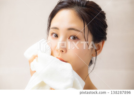A woman wiping his face with a towel A woman wiping his face with a towel 138287896