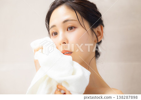 一個女人用毛巾擦臉 一個女人用毛巾擦臉 138287898