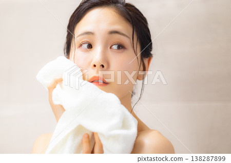 A woman wiping his face with a towel A woman wiping his face with a towel 138287899