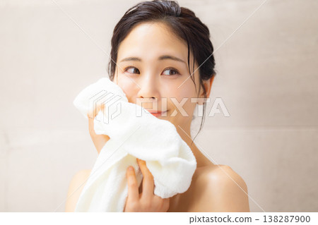 A woman wiping his face with a towel 138287900
