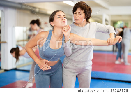 Female pupil clash with training manager during self-defense lesson, repulse charge, intensity of practice 138288176