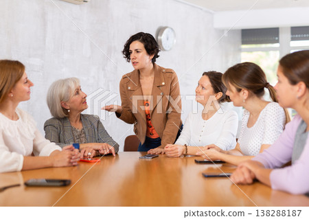 Women have discussion sitting at table in office Women have discussion sitting at table in office 138288187