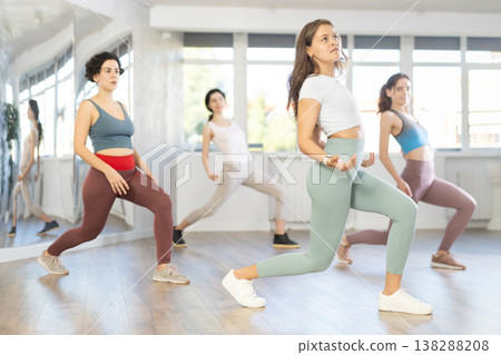 Expressive young woman learning street dancing during group class 138288208