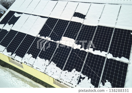 Aerial view of snow melting from covered solar photovoltaic panels installed on house rooftop for producing clean electrical energy. Low effectivity of renewable electricity in northern region winter 138288331