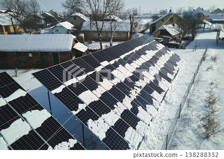 Aerial view of snow melting from covered solar photovoltaic panels at sustainable electric power plant for producing clean electrical energy. Low effectivity of renewable electricity in winter 138288332