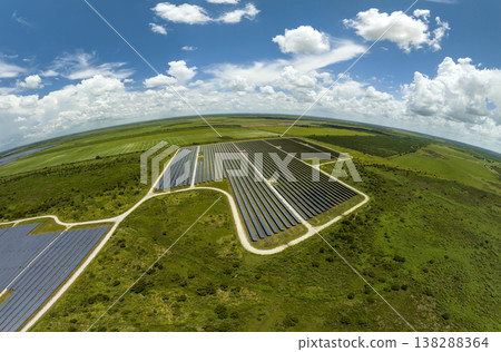 Aerial view of large sustainable electrical power plant with rows of solar photovoltaic panels for producing clean electric energy. Concept of renewable electricity with zero emission Aerial view of large sustainable electrical power plant with rows of solar photovoltaic panels for producing clean electric energy. Concept of renewable electricity with zero emission 138288364