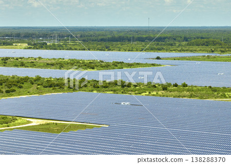 Aerial view of large sustainable electrical power plant with rows of solar photovoltaic panels for producing clean electric energy. Concept of renewable electricity with zero emission Aerial view of large sustainable electrical power plant with rows of solar photovoltaic panels for producing clean electric energy. Concept of renewable electricity with zero emission 138288370