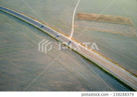Aerial view of intercity road with fast driving cars at sunset. Top view from drone of highway traffic in evening Aerial view of intercity road with fast driving cars at sunset. Top view from drone of highway traffic in evening 138288379