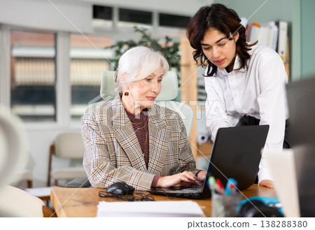 Young woman helping elderly woman with laptop 138288380