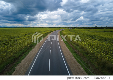 Aerial view of empty intercity road between green agricultural fields. Top view from drone of highway roadway 138288404