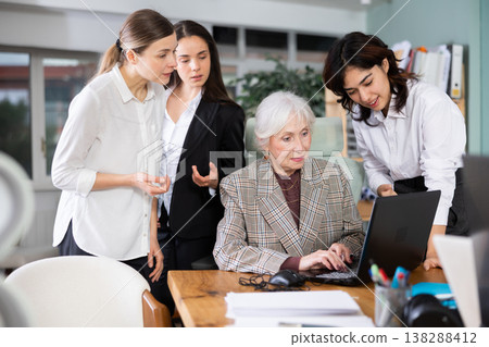Group of women discussing work around laptop in office 138288412