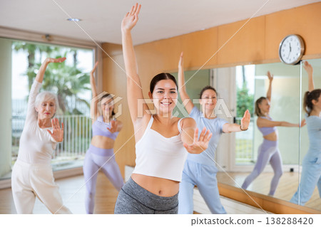 Active young woman practicing aerobic dance in training hall 138288420
