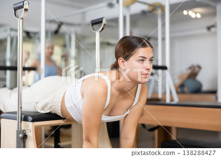 Young girl doing exercises on wunda chair in pilates studio Young girl doing exercises on wunda chair in pilates studio 138288427