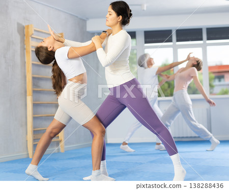 Asian woman practicing palm strike to chin in sparring at self-defense course Asian woman practicing palm strike to chin in sparring at self-defense course 138288436