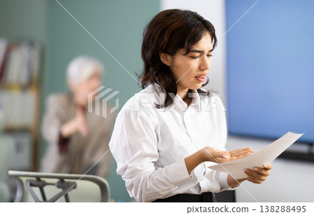 Upset young girl being scolded by manager in background Upset young girl being scolded by manager in background 138288495
