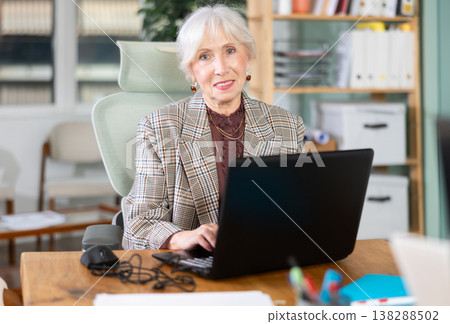 Elderly woman working on laptop in office 138288502