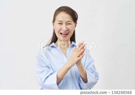 An elderly woman clapping against a white background. An elderly woman clapping against a white background. 138288568