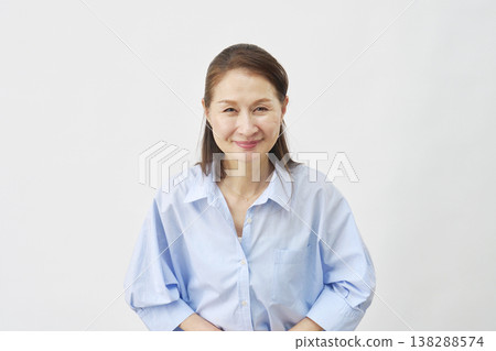 Elderly woman bowing on white background, looking at camera 138288574