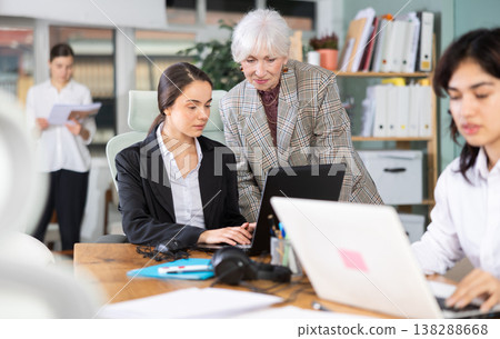 Elderly woman helping young woman with laptop 138288668