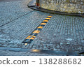 Industrial speed breaker on a wet stone pavement in an urban environment with stone walls 138288682