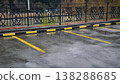 Empty parking lot after rain featuring yellow markings, a black fence, and a river background 138288685