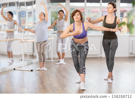 Adult woman teacher correcting beginning dancers 138288712