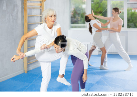 Young and elderly women training self-defense techniques 138288715
