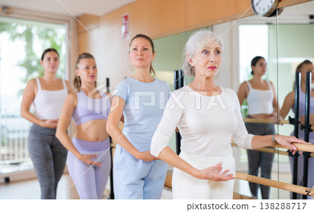 Adults learning to dance ballet in dancing school Adults learning to dance ballet in dancing school 138288717
