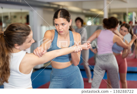 Women in pair perform effective impact on pain points while learning self-defense. Women in pair perform effective impact on pain points while learning self-defense. 138288722