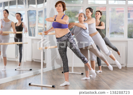 Woman practicing arabesque at beginner ballet barre class Woman practicing arabesque at beginner ballet barre class 138288723