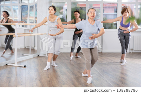 Group of women of different ages are learning various dance and ballet movements in studio 138288786