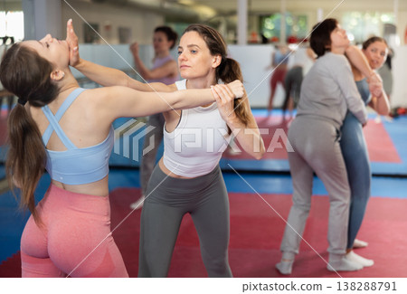 Women in pair perform effective impact on pain points while learning self-defense. 138288791
