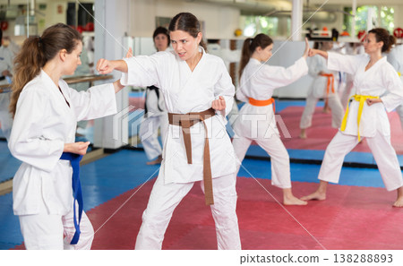 Women pupils train to perform defensive karate installations and attacking combat techniques Women pupils train to perform defensive karate installations and attacking combat techniques 138288893