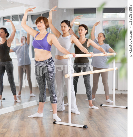 Group of women stand in second position at barre Group of women stand in second position at barre 138288898