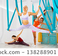 Aerial yoga in hammock. Slim woman performs gravity yoga and stretching exercises. Healthy lifestyle concept 138288901