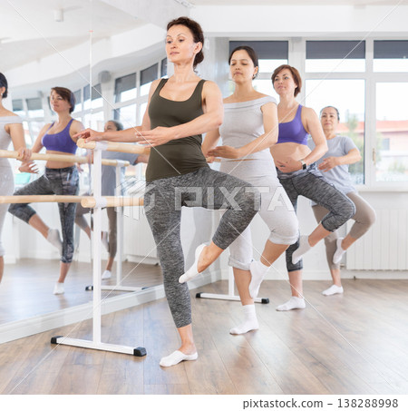 Woman mastering passe ballet move at amateur dancers rehearsal 138288998