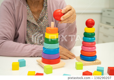 Asian elderly woman patient  learn practical motor game skills rehabilitation. 138290207