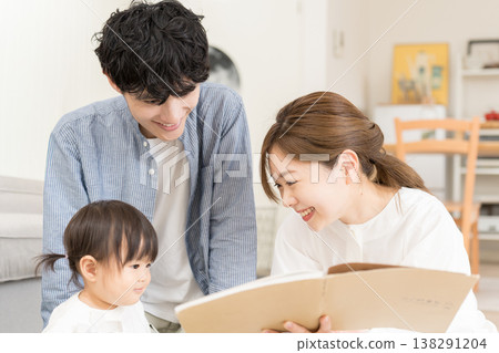 一對年輕夫婦給嬰兒讀圖畫書 138291204